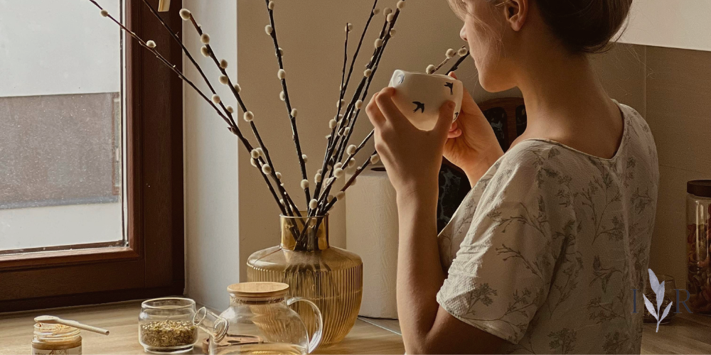 slow living example enjoying tea quietly by a window in natural morning light